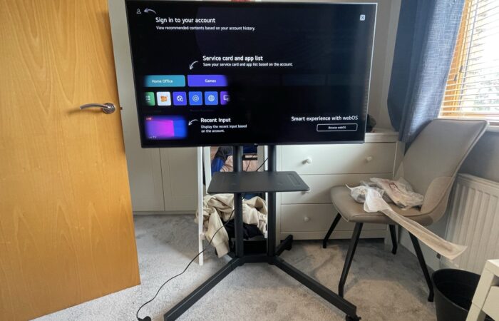 TV installed on a mobile floor stand with shelf, set up and ready to use