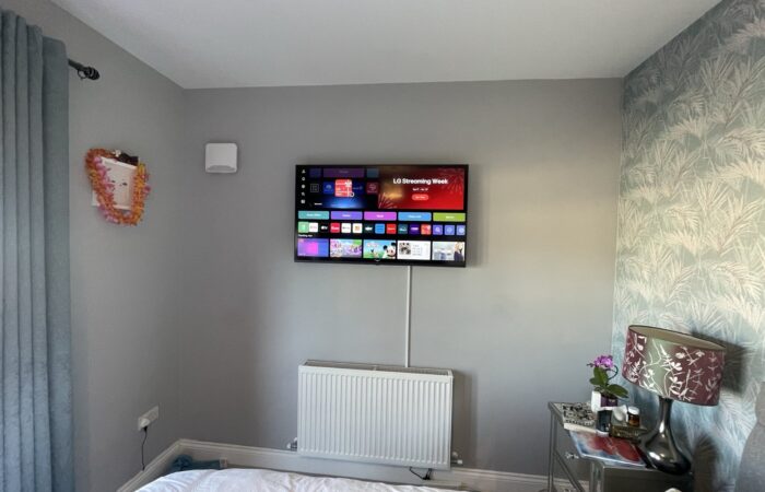 43-inch smart TV wall mounted in a bedroom with the cable hidden in neat white trunking