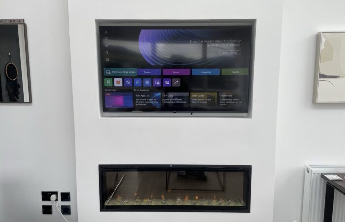 55-inch TV recessed into a media wall above a built-in electric fireplace