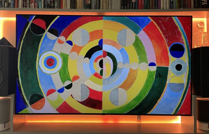 Wall-mounted TV with warm LED ambient backlight glowing behind the screen
