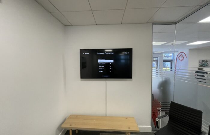 TV wall mounted in an office meeting room and connected to the network